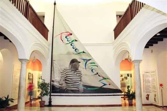 Interior del hall principal con gran bandera decorativa y arcos