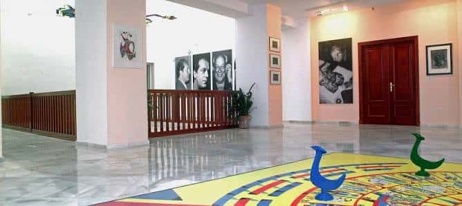 Sala de exposiciones con obras en pared y suelo decorado
