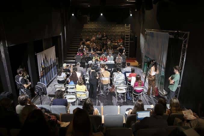Evento en curso con audiencia y panelistas en el escenario