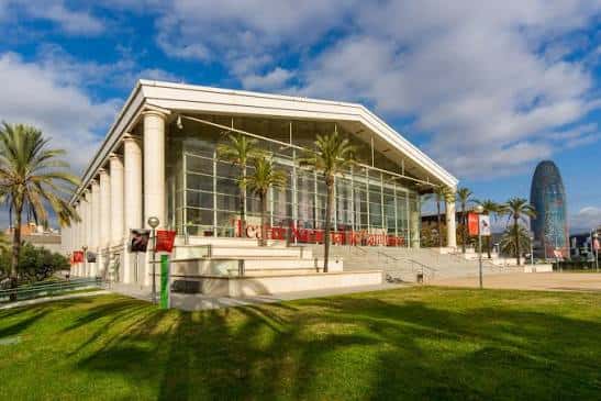 Exterior del teatro con cielo parcialmente nublado y edificio Torre Glòries al fondo