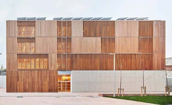 Fachada moderna del Centre Cívic Trinitat Vella con revestimiento de madera y paneles blancos