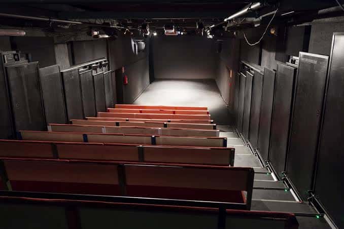 Interior del auditorio con butacas rojas y escenario
