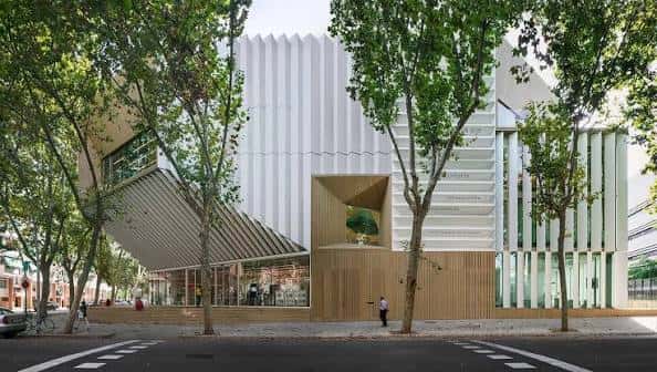 Fachada exterior de la biblioteca con árboles y diseño moderno