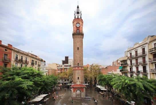 Vista panorámica de la Plaça de la Vila de Gràcia con su icónico reloj y edificios circundantes
