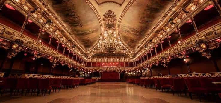 Vista panorámica del interior del salón principal de La Paloma con su imponente techo pintado y arañas de cristal