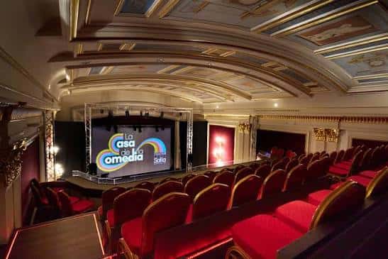 Vista panorámica del interior del Teatro Sofía con butacas rojas y escenario iluminado