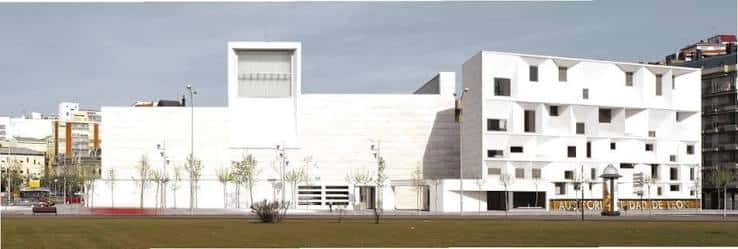 Vista frontal del Auditorio Ciudad de León con césped y árboles en primer plano