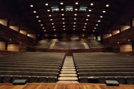 Vista general del interior del auditorio con escenario y sistema de iluminación