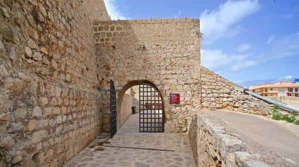 Entrada arqueada con puerta de hierro en las murallas históricas