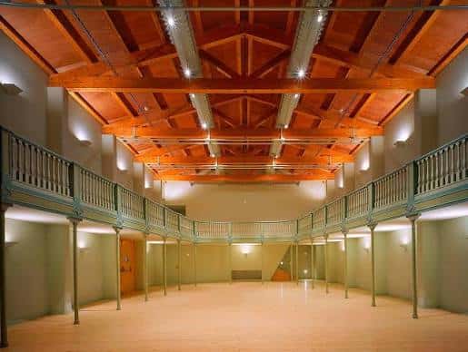 Espacio polivalente del Cal Ninyo con suelo de madera y balcones laterales