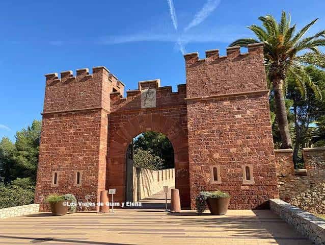 Entrada principal del castillo con arco de piedra y palmeras, ambiente acogedor para celebraciones