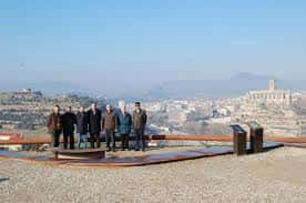 Grupo de personas posando frente al Pou de Llum con vista a la ciudad de Manresa