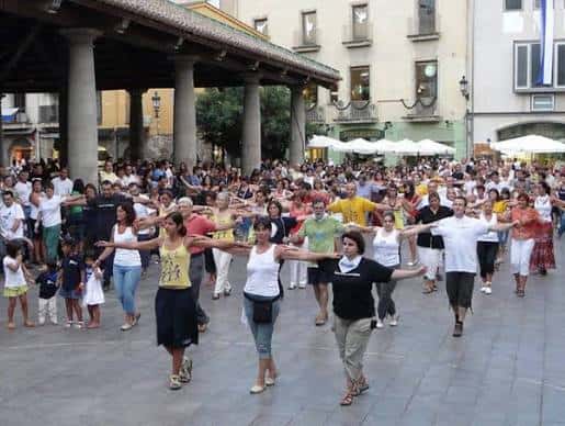 Evento comunitario en la Plaça de la Mediterrània con participantes realizando actividad grupal