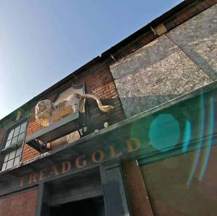 Fachada exterior del edificio Treadgolds con letrero y escultura de león