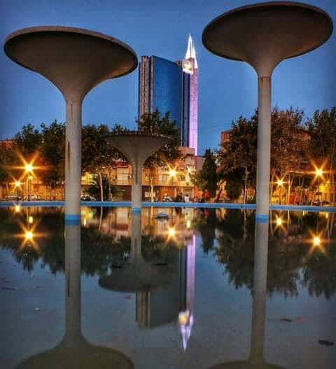 Las tres copas iluminadas al atardecer con reflejos en el agua