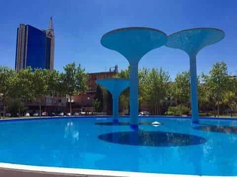 Las tres copas en un día soleado con cielo azul y edificio moderno al fondo