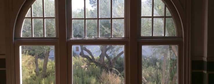 Ventana arqueada con vista al jardín exterior