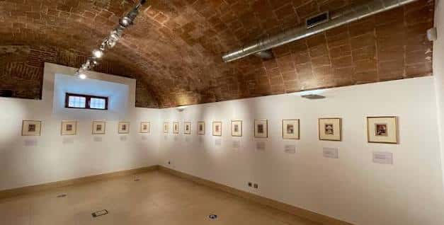 Galería de exposiciones con bóveda de ladrillo y obras enmarcadas