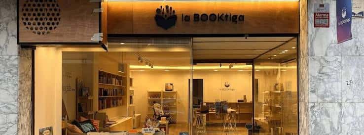 Fachada de la librería La BOOKtiga con su logotipo y escaparate iluminado