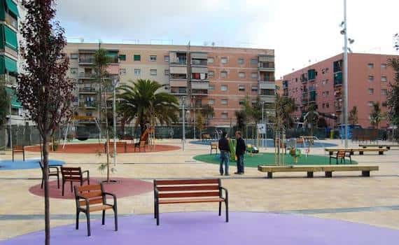 Área recreativa de la plaza con bancos y zonas de juego para niños