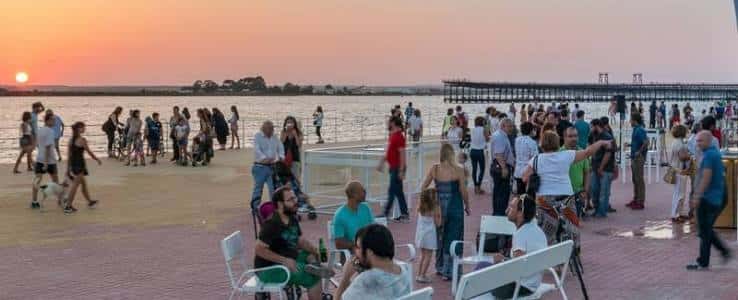 Amanecer en el Paseo de la Ría con personas disfrutando del paseo y la vista al río
