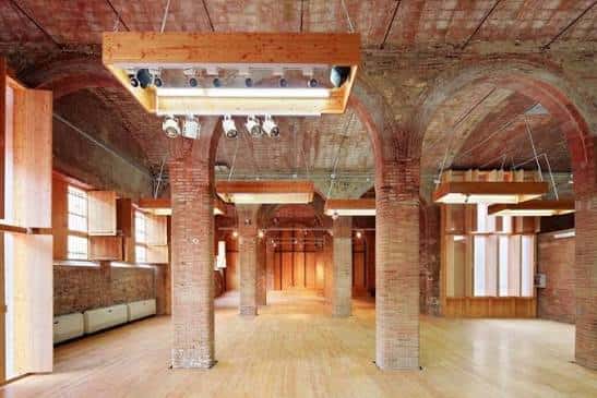 Interior del hall principal con bóvedas de ladrillo y suelo de madera