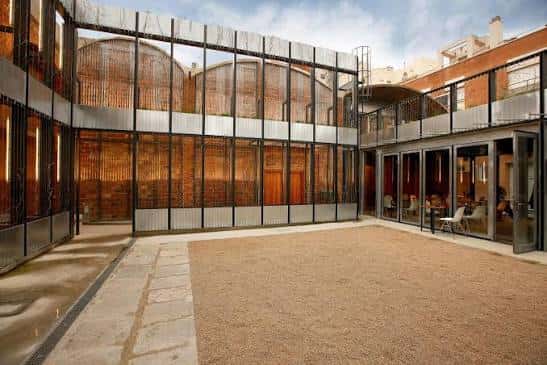 Patio central con fachada de cristal y estructura metálica