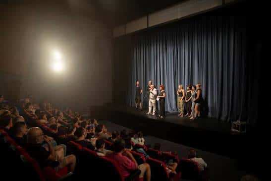Escenario con actores y público durante una función