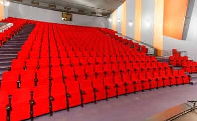 Interior del auditorio con butacas rojas y escenario