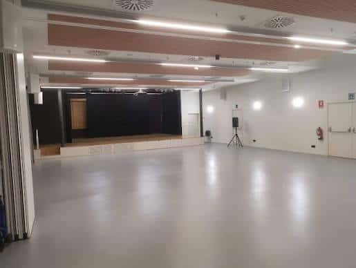 Sala de eventos principal con escenario y suelo pulido