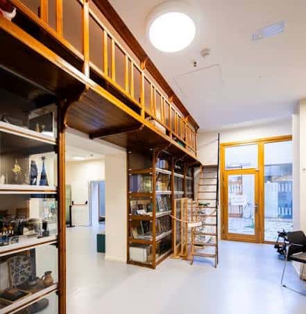 Interior con biblioteca y balcón de madera