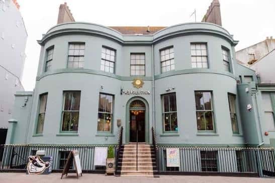 Fachada exterior del local Revolution Brighton con su distintiva pintura verde azulado