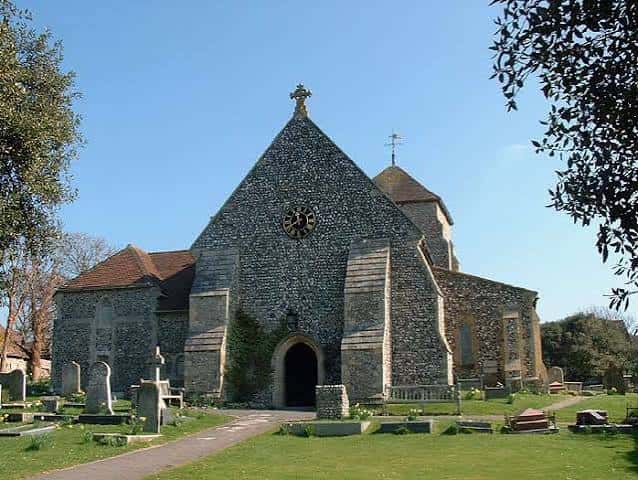 Fachada principal de la iglesia de St Margaret's con reloj y cementerio