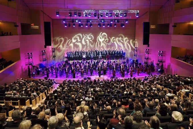Concierto en el auditorio con orquesta y público en pie