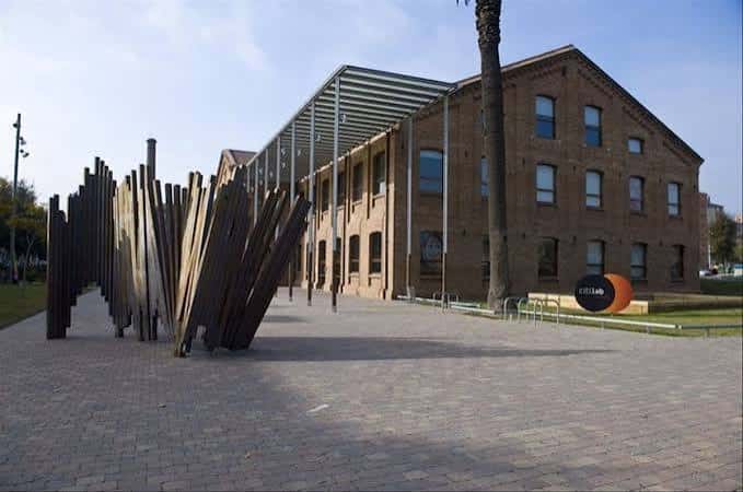Fachada principal de Citilab con escultura de madera en el patio