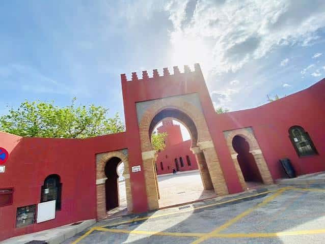 Entrada monumental del Castillo de Bil Bil con arco de herradura y cielo soleado