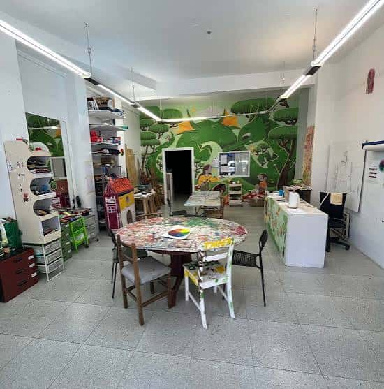 Vista general del taller de arte con murales coloridos y mesas de trabajo