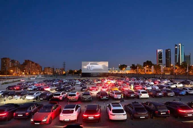 Escena nocturna del Autocine Madrid con el proyector encendido y las luces de los coches