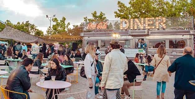 Área de restauración del Autocine con el Diner y la gente disfrutando del ambiente