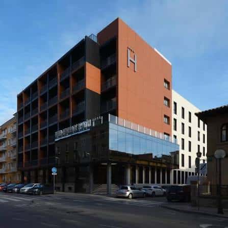 Vista exterior del Hotel Pedro I de Aragón con fachada moderna y tonos naranjas