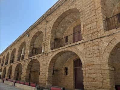 Fachada de la antigua Casa del Niño Jesús en Cádiz con arcos de piedra y balcones