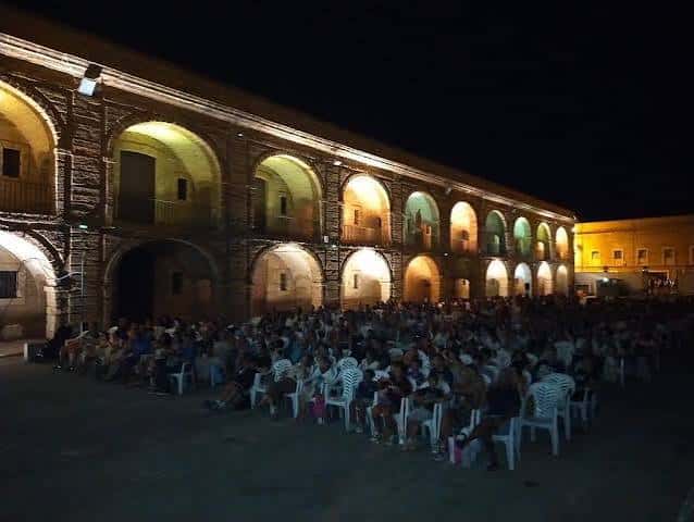 Evento de cine al aire libre en el patio de la Casa del Niño Jesús con público sentado