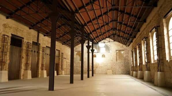 Interior del espacio de eventos con techos de vigas de hierro y paredes de piedra