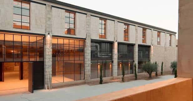Fachada exterior del edificio con grandes ventanales y diseño industrial renovado