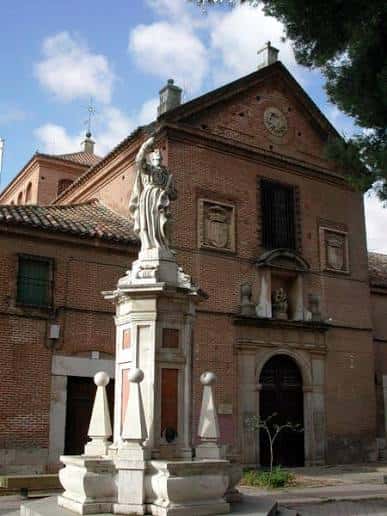 Fachada principal del Convento del Corpus Christi con estatua en primer plano