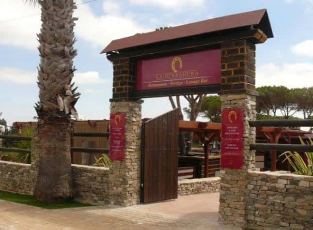 Acceso al restaurante La Herradura dentro del complejo