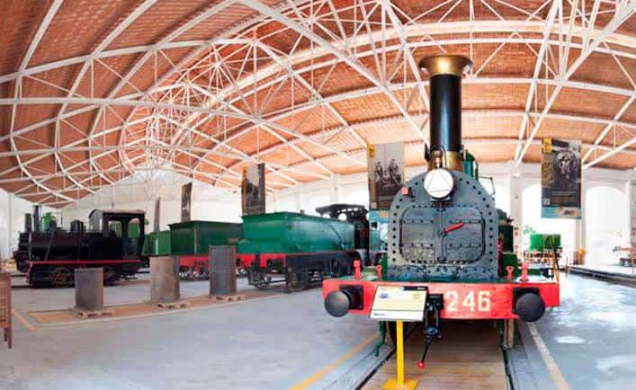 Interior del museo con locomotoras de vapor expuestas bajo techos abovedados