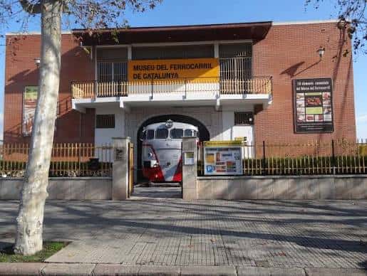 Fachada principal del Museo del Ferrocarril de Cataluña con tren en la entrada