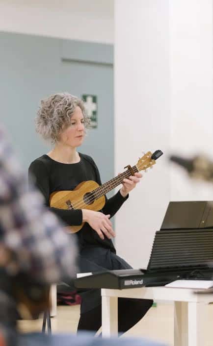 Mujer tocando ukelele en clase de música