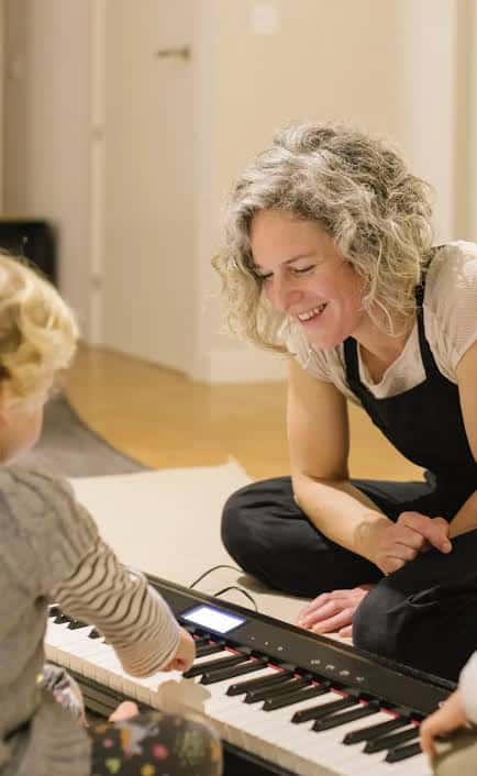 Profesora enseñando piano a un niño pequeño